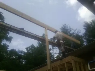 Carpenter setting a ridge beam over a new addition frame — Ice Dam Removal by Roofing Brothers in Streator