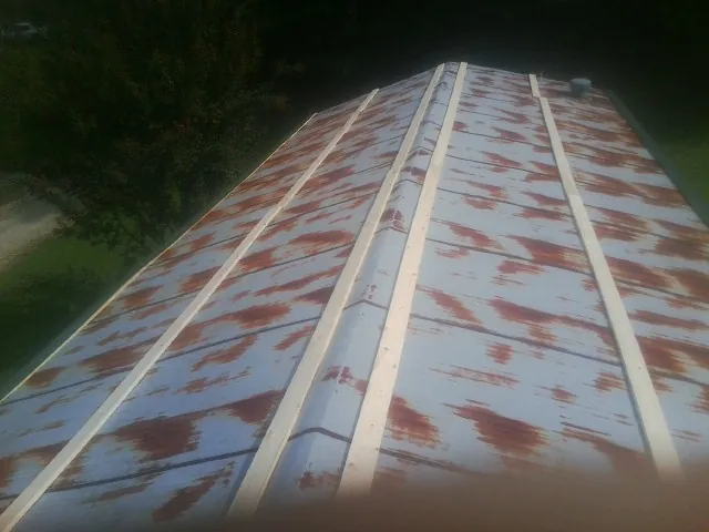 Rusted metal roof panels with new wood purlins before replacement — Storm Damage Roof Repair in Streator by Roofing Brothers