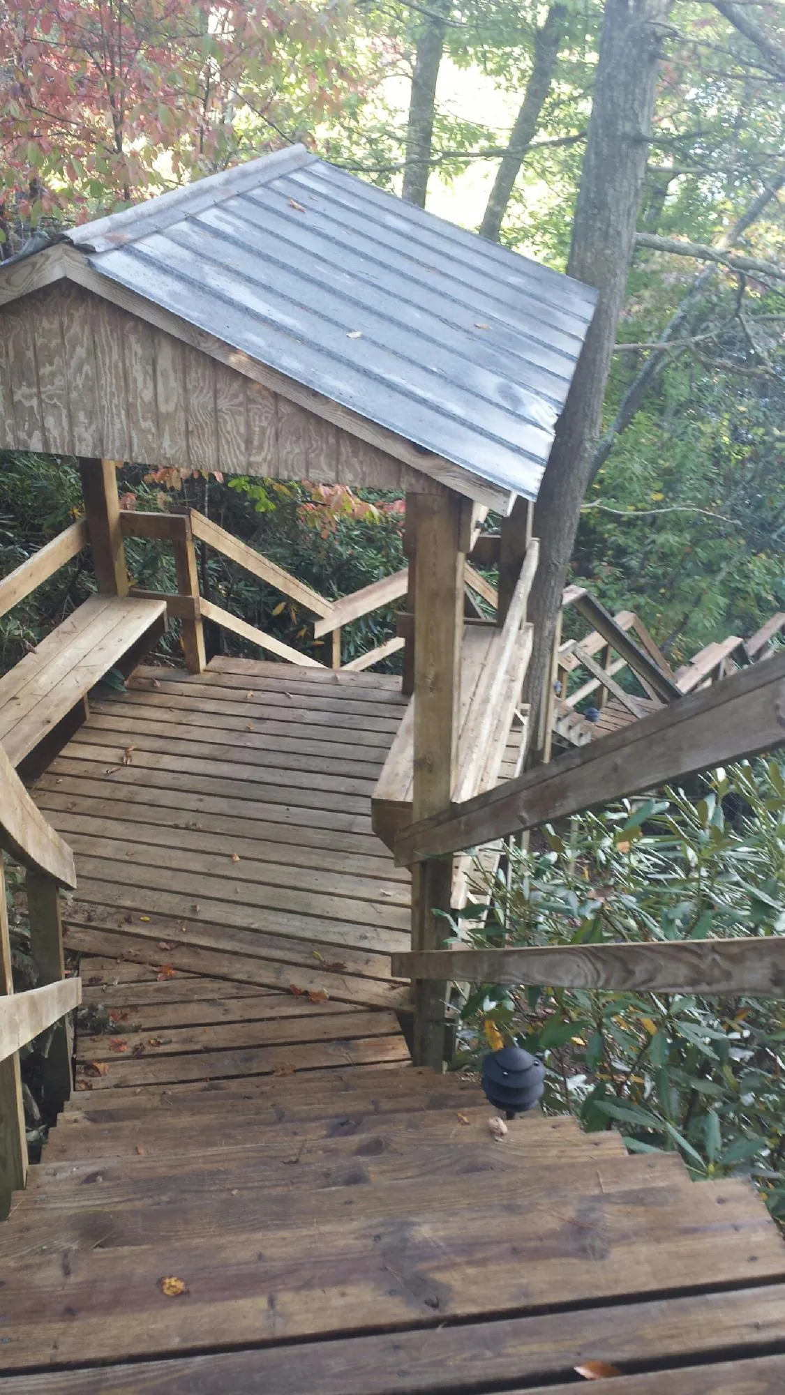Metal roofed shelter over wooden steps on a wooded walkway — Skylight Repair & Installation work by our crew in Streator