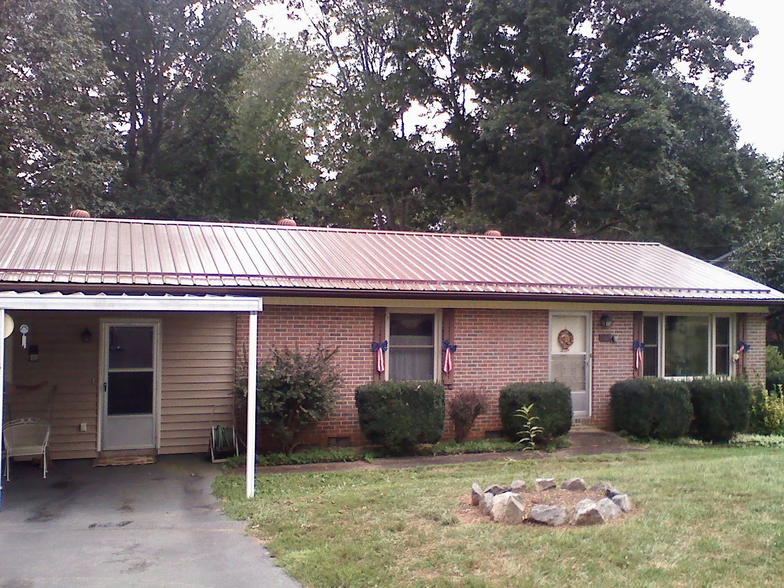 Bronze metal roof and carport on a brick ranch home — Roof Repair work by our crew in Streator